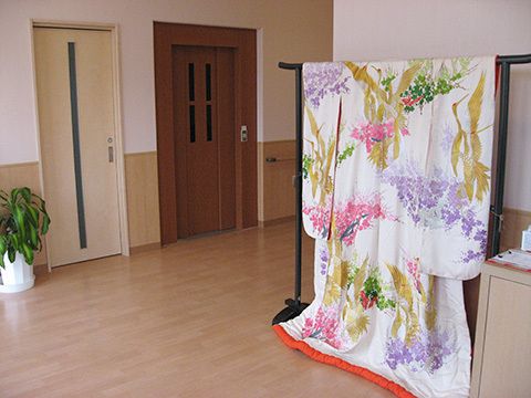 はなやかな着物の打掛が飾られている施設内の廊下の様子。エレベーター付近の写真