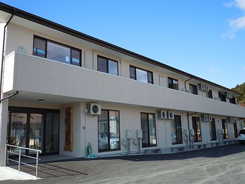 横に長い集合住宅風の建物の外観。フレンズハウス城慈の外観写真