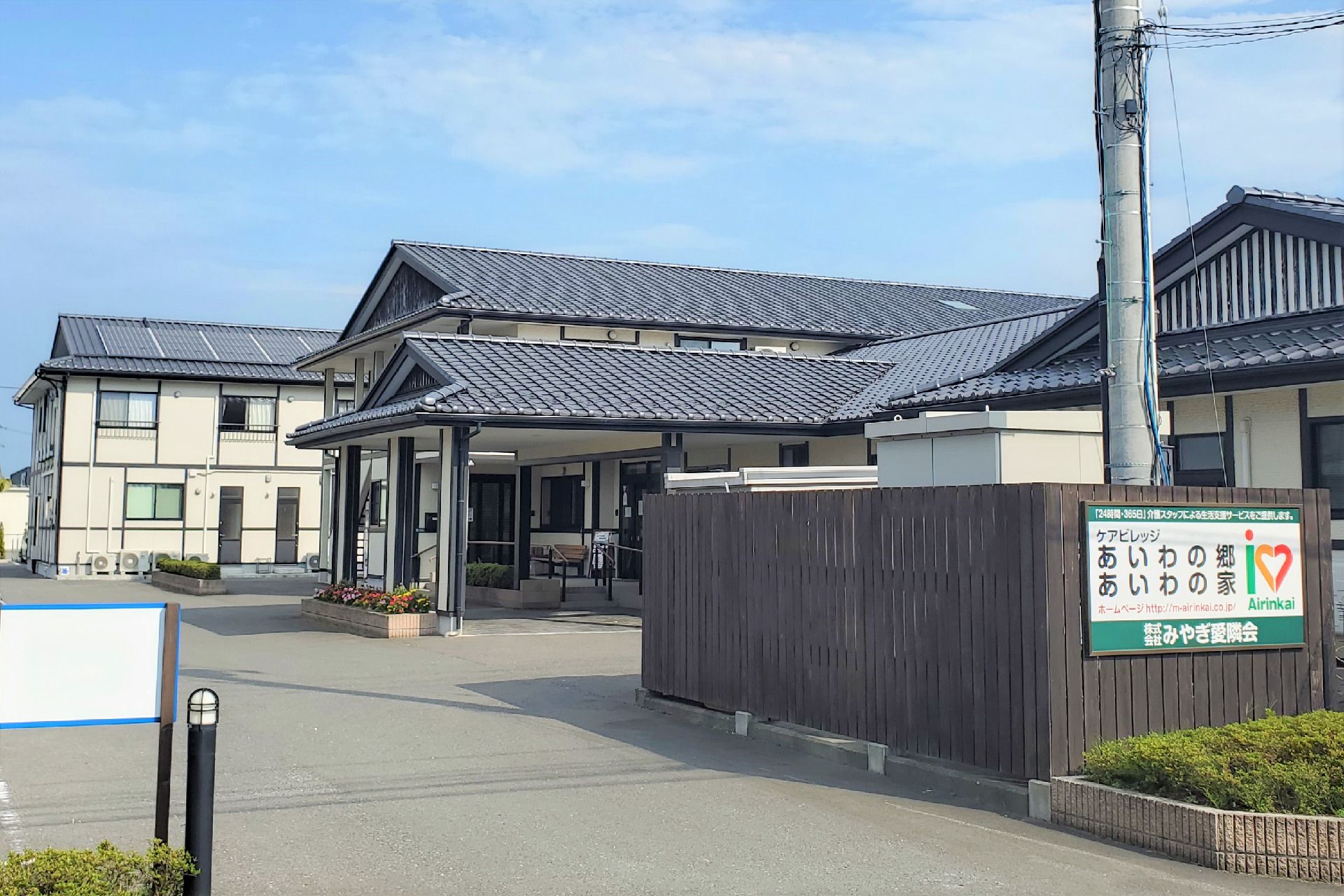 川沿いにある小さな建物の写真。エイジングハウスあいわの郷の外観