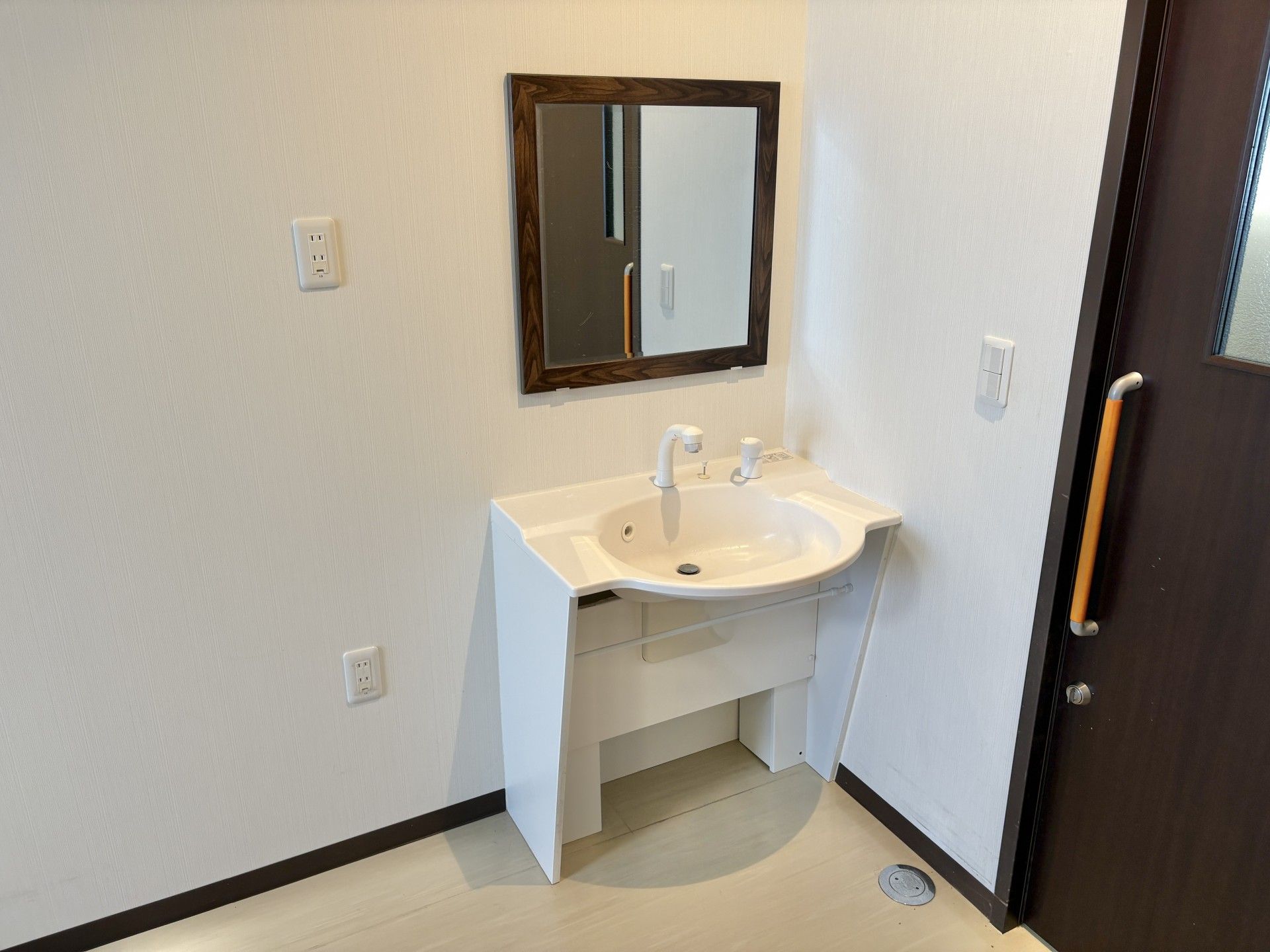 車椅子に乗って手を振る高齢女性と介助をする女性ヘルパー