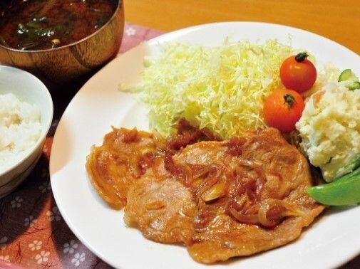 ピンクのポロシャツを着た女性スタッフと高齢女性が笑顔で拍手をしながら何かを鑑賞している。