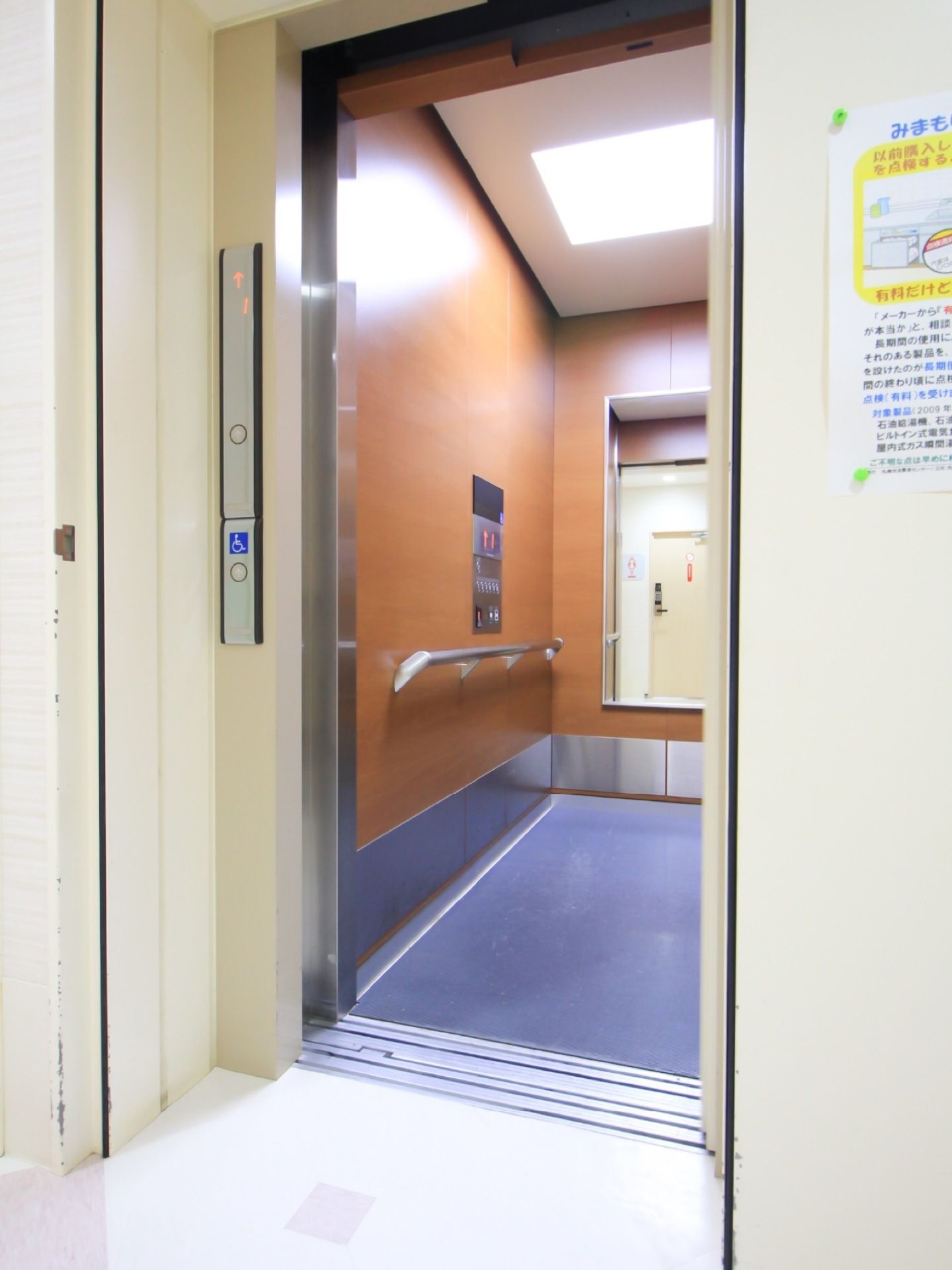 エレベーター内には手すりがある。足元は段差がなく車椅子でもスムーズにご使用いただける。車椅子用に低めの位置にもボタンがある。