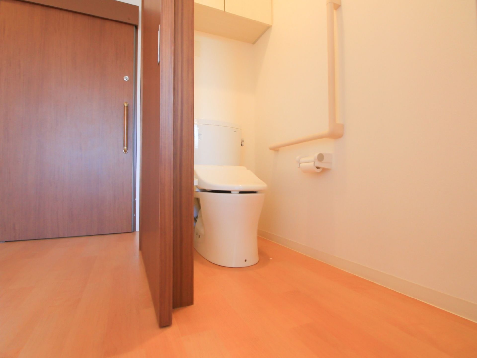 車椅子をご利用の方に考慮し、トイレの扉はスライド式を設置している。壁にはＬ字型の大きな手すりが付けられている
