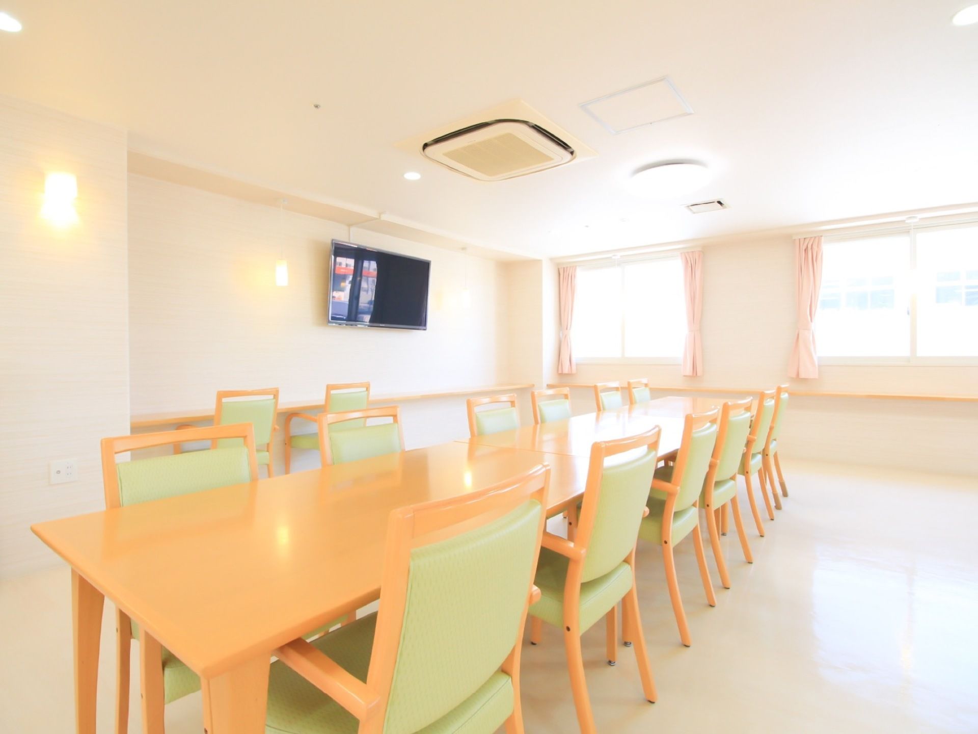 長机が３卓、椅子が12脚設置されている。壁は白を基調とした作りになっており、テレビ、手すりが付けられている。