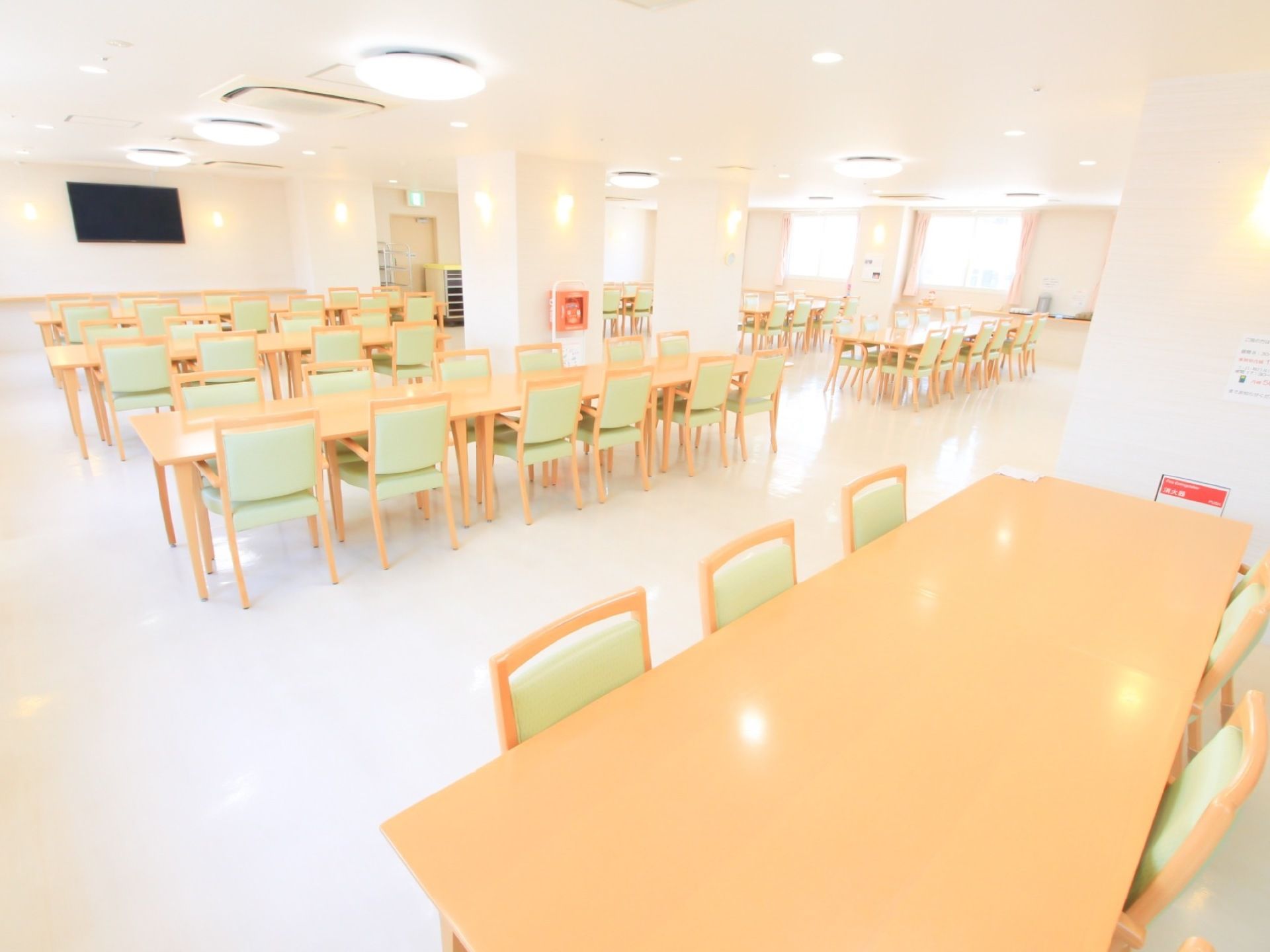 多くのテーブル、椅子が配置されている。床、壁、天井すべてが白色で作られており、照明も多いため、部屋全体が明るい。