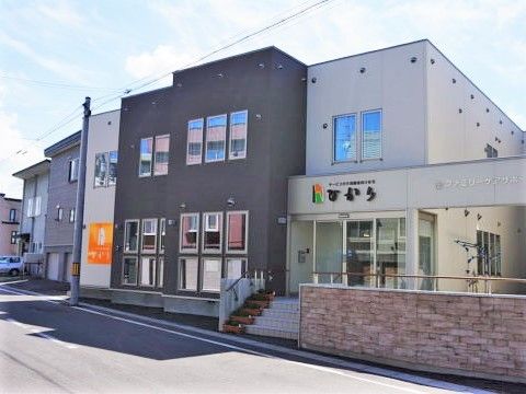 ツートンカラーのサービス付き住宅の外観。凹凸の少ない直線的な外観写真