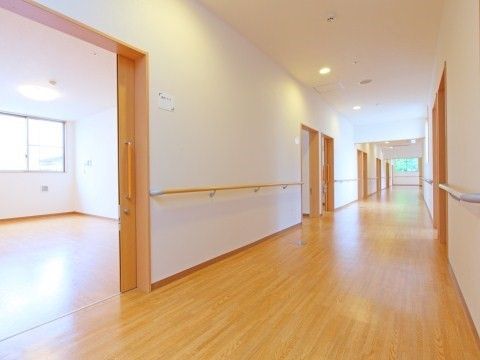 居室入口部分以外の両側の壁に手すりが設置されている廊下