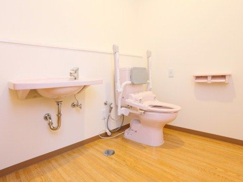 隅々まで掃除の行き届いた、広々としたトイレ。手すりや緊急ボタンも設置されており、安全面も配慮した設計になっている。