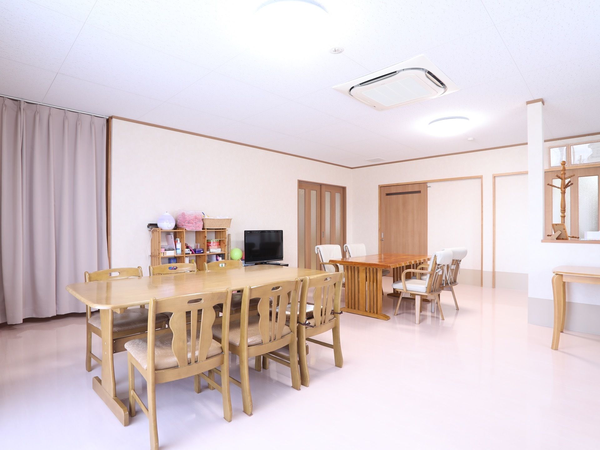 食堂には6人掛けと4人掛けのダイニングテーブルが用意されている。壁際にはテレビや棚などが設置されており、天井には空調が設備されている。