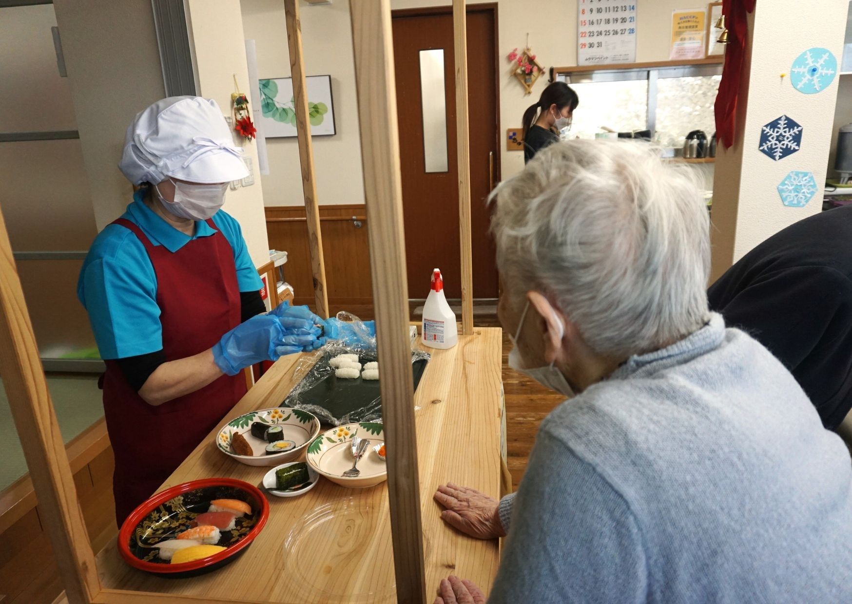 食事を準備するスタッフと利用者