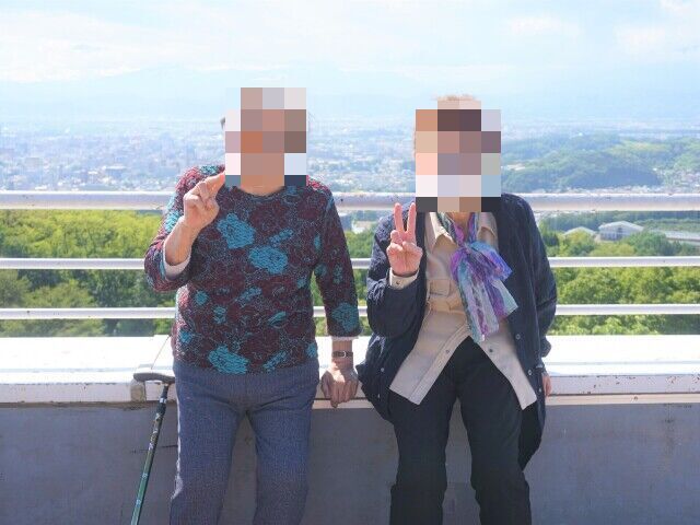 サンタクロースとトナカイに扮したスタッフと笑顔で写真に納まる高齢者の様子