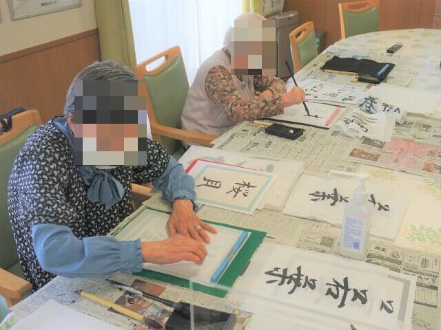多くの高齢者とスタッフ、外部の人たちが並んで記念写真に納まる様子