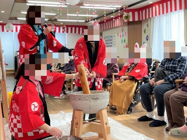 入居者が手本を見ながら習字を行う様子