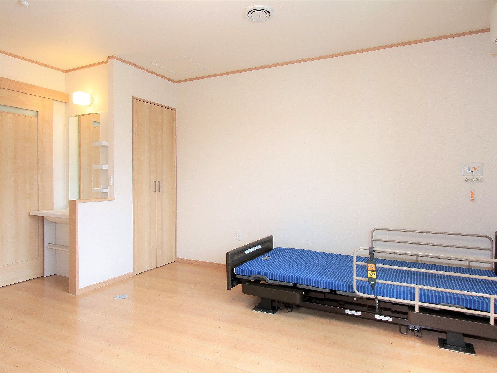 居室はトイレ付きのワンルームとなっている。床には明るい色で光沢のあるタイプのフローリングが使われている。