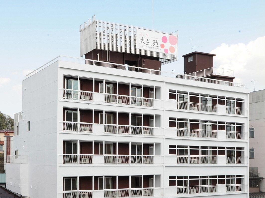 白を基調とした建物はマンションのように大きく、屋上やベランダが付いている。