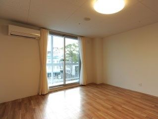 大きな窓があり明るい雰囲気。居室には、カーテンや照明に加えてエアコンもついている。