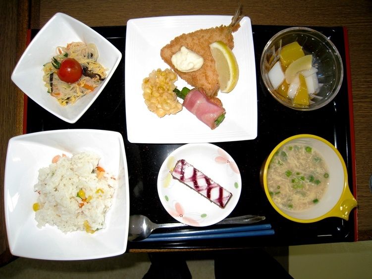 炊き込みご飯、2品のおかず、スープ、果物、デザートが盛り付けられたお膳