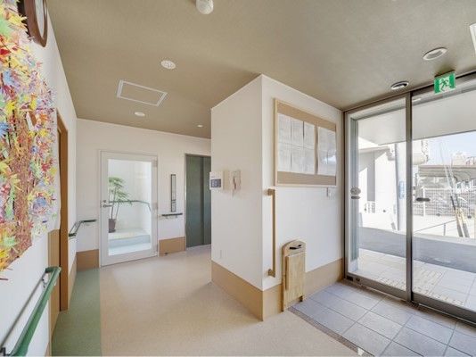 玄関の出入り口には手すりや収納型のベンチが付き、館内には入居者の作品も飾られている。