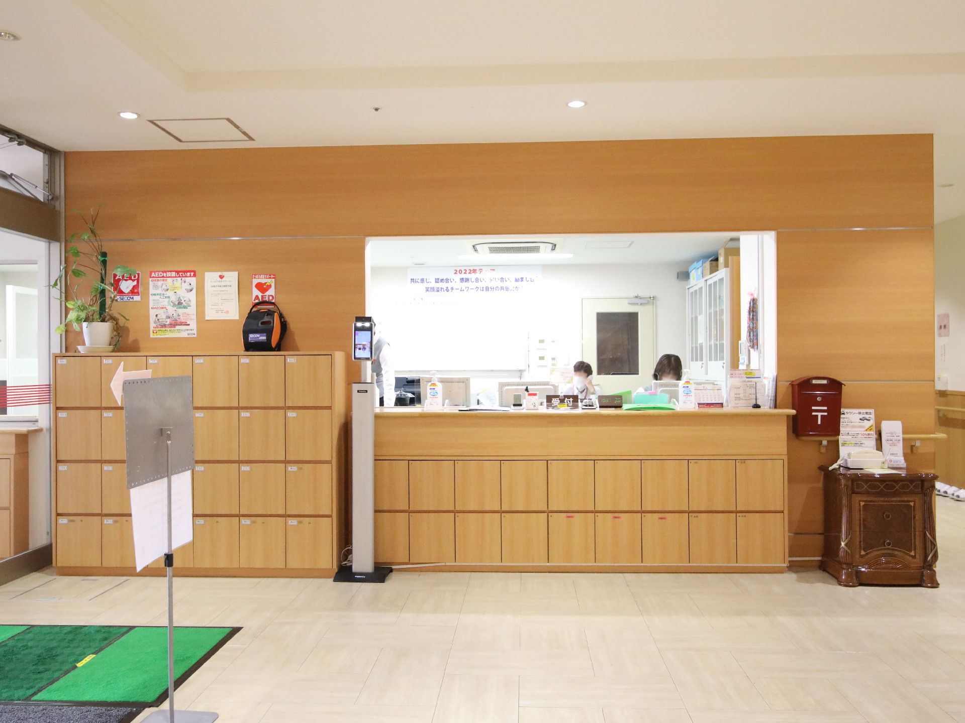 壁に靴箱と受付口があるエントランス