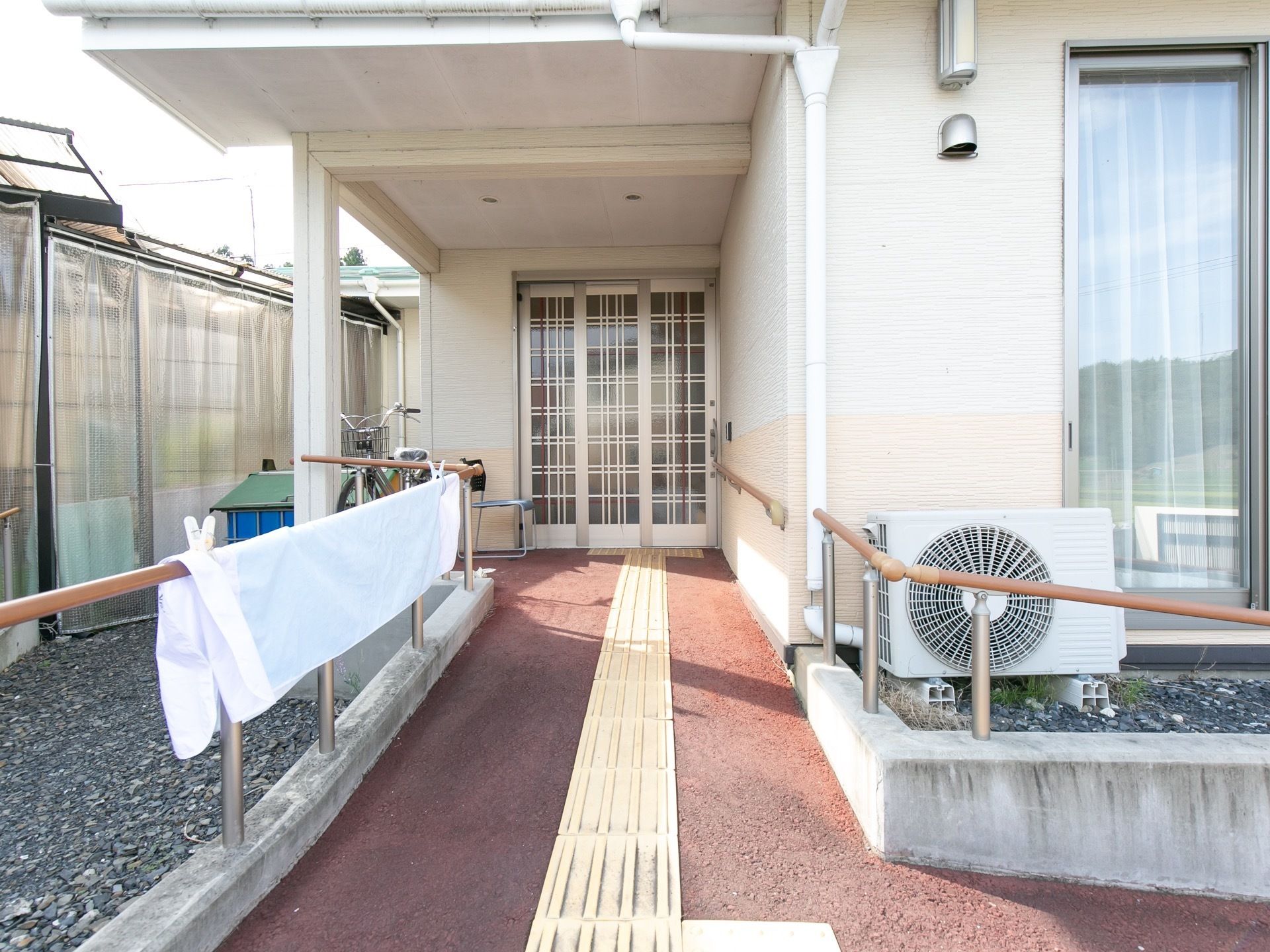 玄関までの通路に手すりがある。屋根が取り付けられており、雨の日や陽射しの強い日も安心である。
