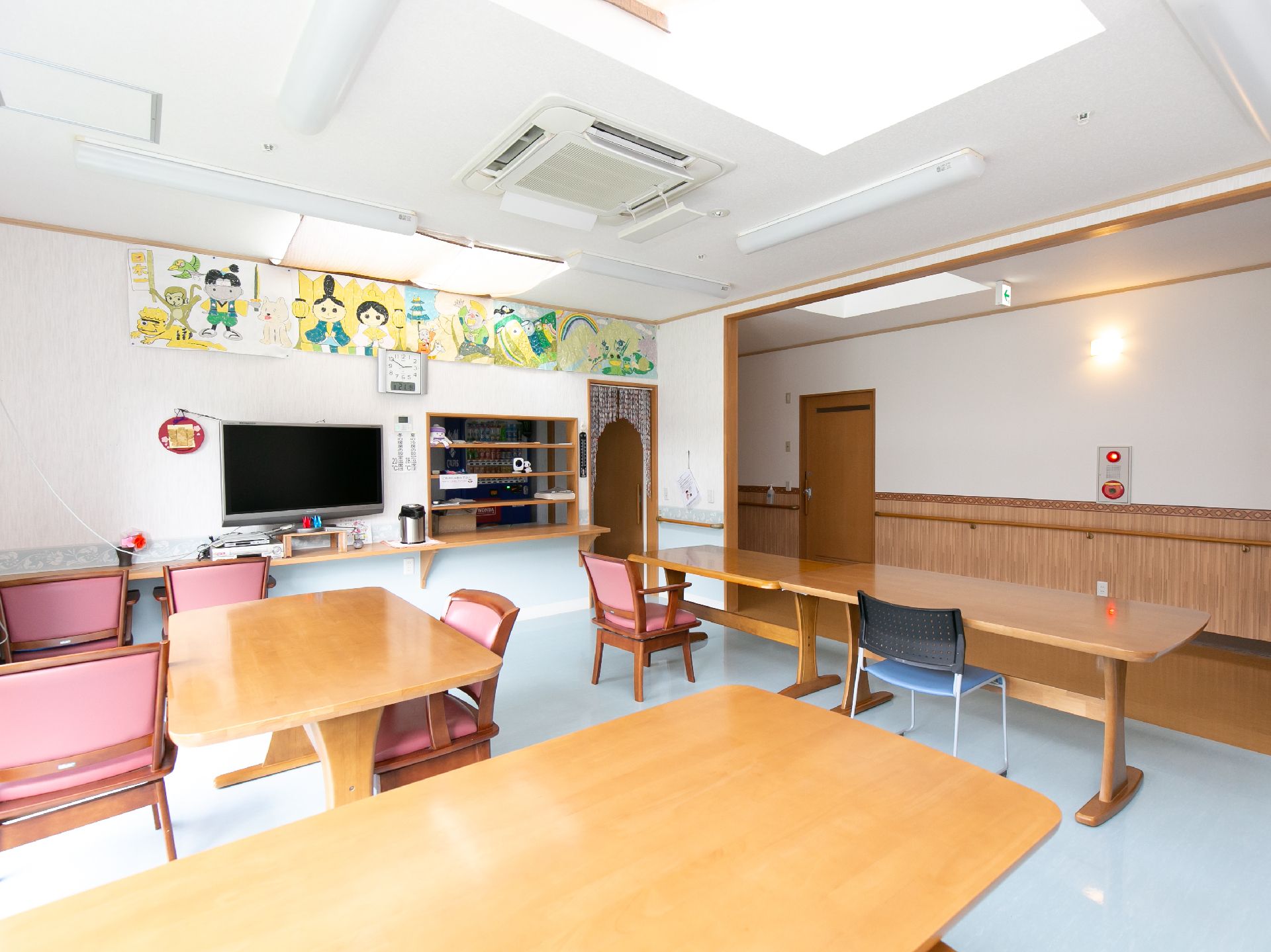 ひな祭りや昔話の絵が壁に飾られ、テレビが設置されている食堂