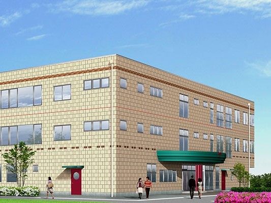 花や木に囲まれた明るい雰囲気のベージュの建物は３階建てで、周辺には人もたくさんいる