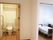 右側にはベッドが2台置かれているフローリングの部屋、左側には手すりが付いたトイレがある。