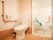 浴室へと続く場所にトイレが置かれている。仕切りはなく広く、壁には手すりが設置されており、便座には蓋が付いている。