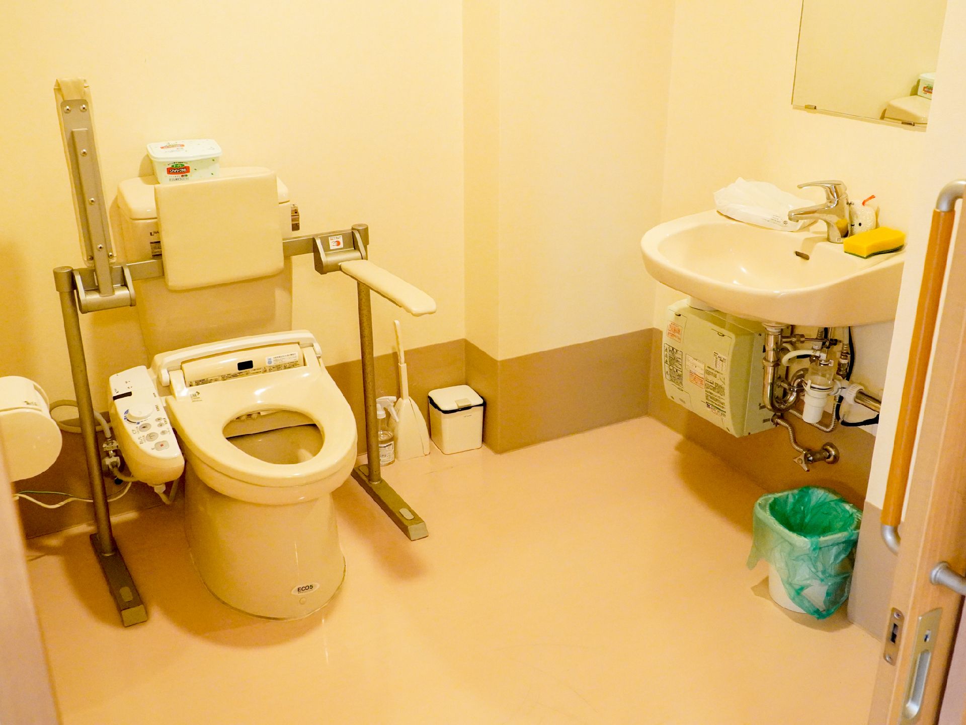 鏡の付いた洗面台とトイレが設置された空間