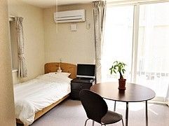 テーブルセットやベッド、エアコンが付いた居室には大きな窓が付いている。