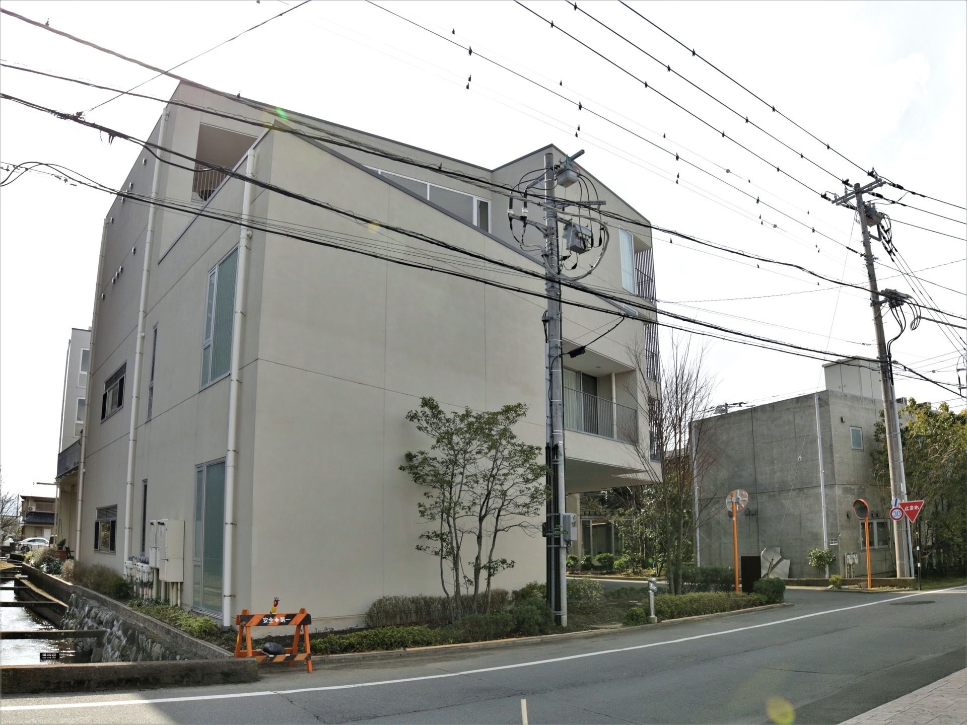 施設の出入口両脇にミラーが設置されている。大きな道路に面しているので、来館時に迷う心配が少ない。施設の裏手に用水路が流れている。
