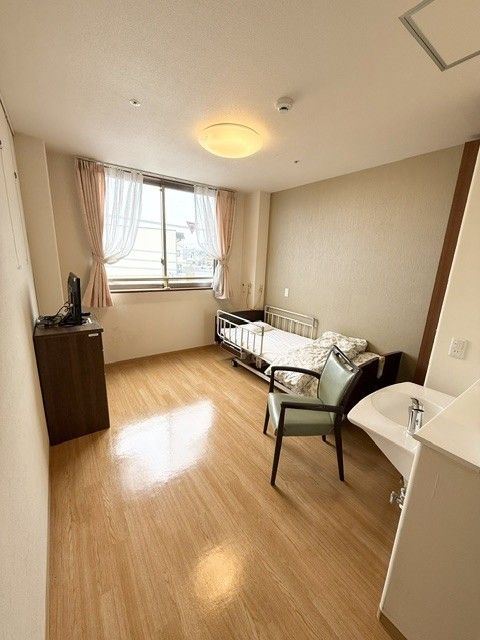 窓際のベッドと椅子の部屋