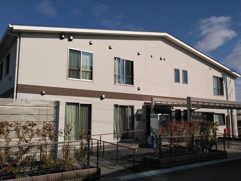 ベージュの外壁で三角屋根の2階建て建築物