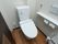 白を基調とした清潔感がある個室トイレである。呼び出しボタンが壁に設置されている。緊急時に、すぐにスタッフに連絡をすることができる。