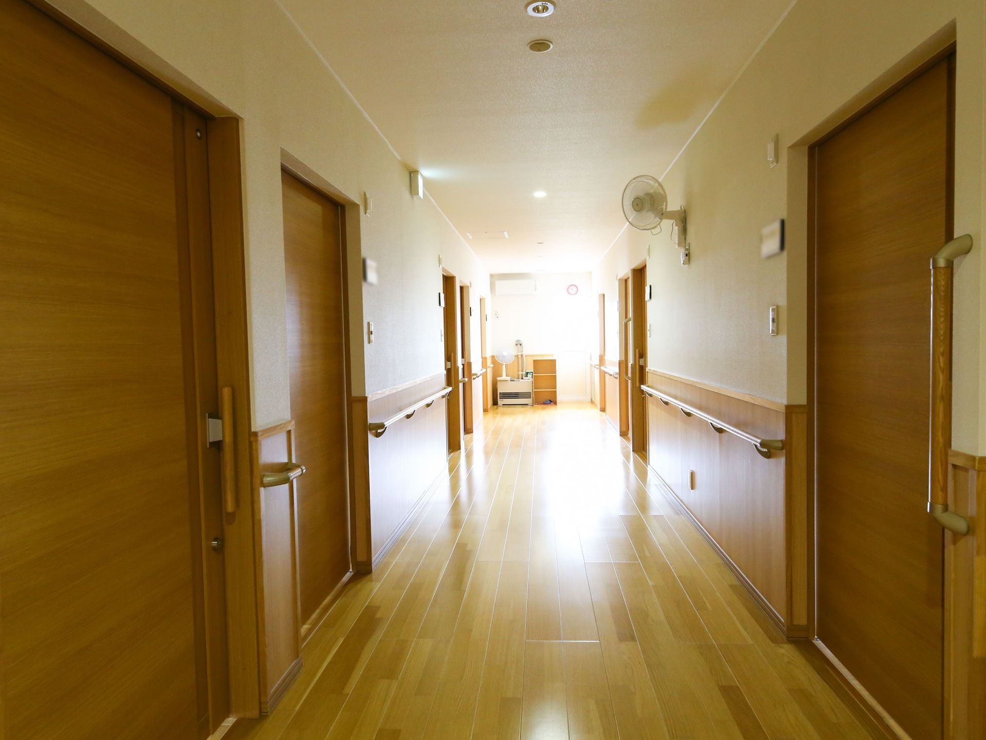 木の温もりを感じる通路である。各部屋の扉はスライド式になっている。壁には扇風機が取り付けられている。