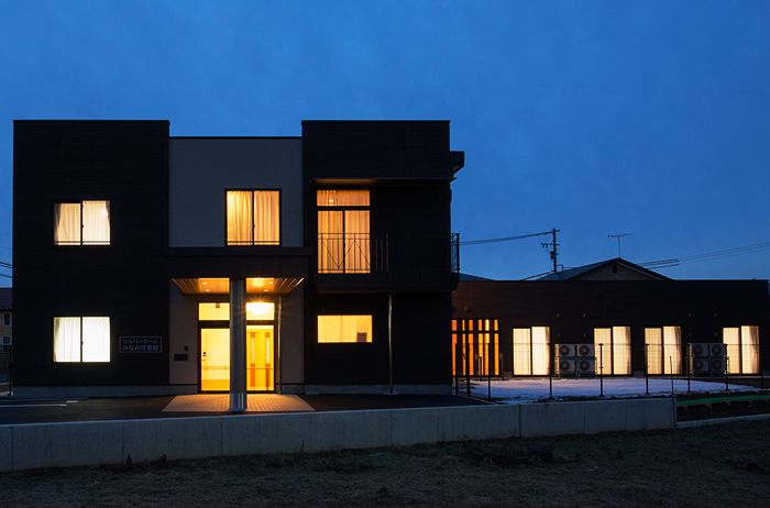 夕暮れ時の温かい光が灯る建物外観