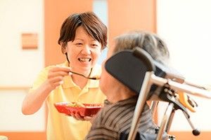 笑顔で食事介助するスタッフ