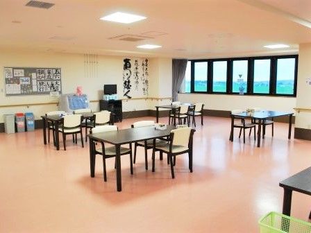 書道の作品などが飾られた食堂は日当たりもよく、ダイニングテーブルやテレビがある。