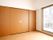 大きなクローゼットが設置されているフローリングの部屋にはカーテンのない大きな窓が付いている。