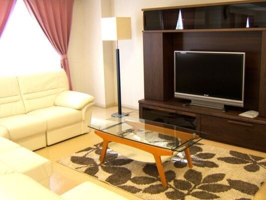大きなテレビを囲むようにして白いソファが置かれ、ローテーブルも設置されている。