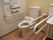 手すりや緊急時呼び出しボタンが備わったトイレである。便器の側に洗面台があり、洗面台の両側にも手すりがある。