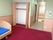 収納と介護用ベッドが写っている施設内の居室。奥の方にトイレと入り口のドアがある