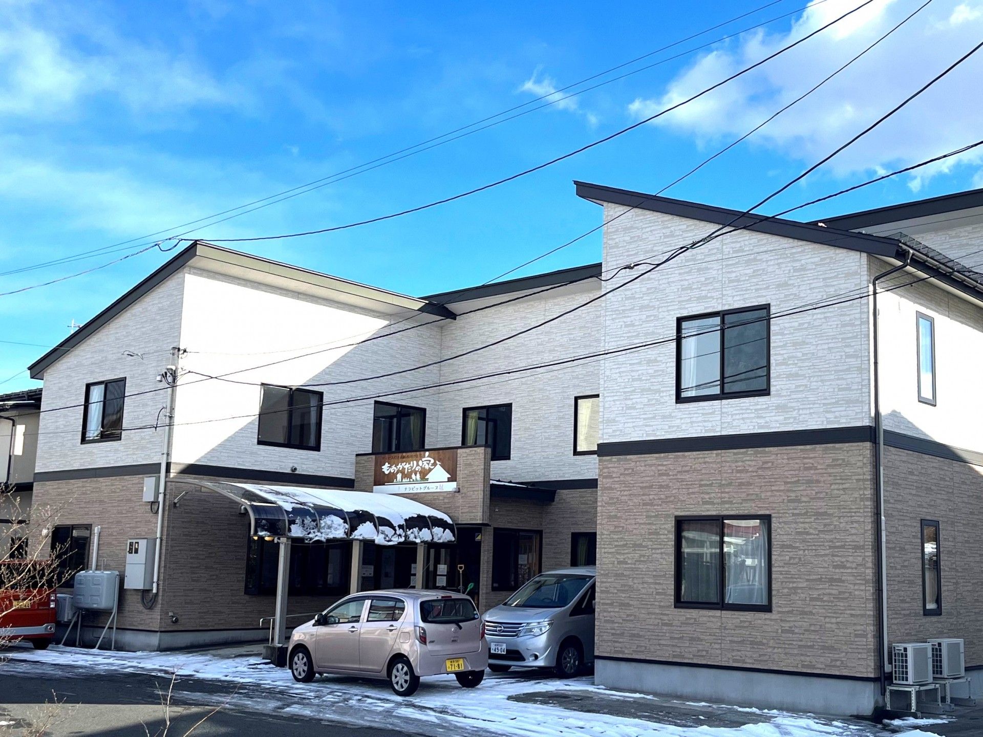 車いすに乗った男性と寄り添う介護スタッフ