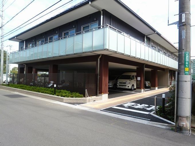2階建ての建物は道路に面していて、1階部分には駐車スペースがあり、2階にはベランダが付いている。