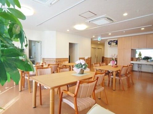 食堂に多くの椅子とテーブルが置かれている。天井にエアコンが２つ設置されている。