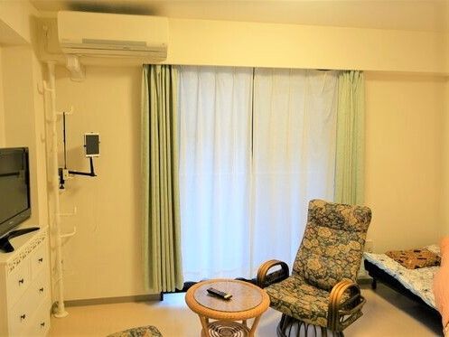 ご入居前の居室である。エアコンやベランダが完備され、サッシ戸は開かれている。天井に設置された照明器具は点けられている。