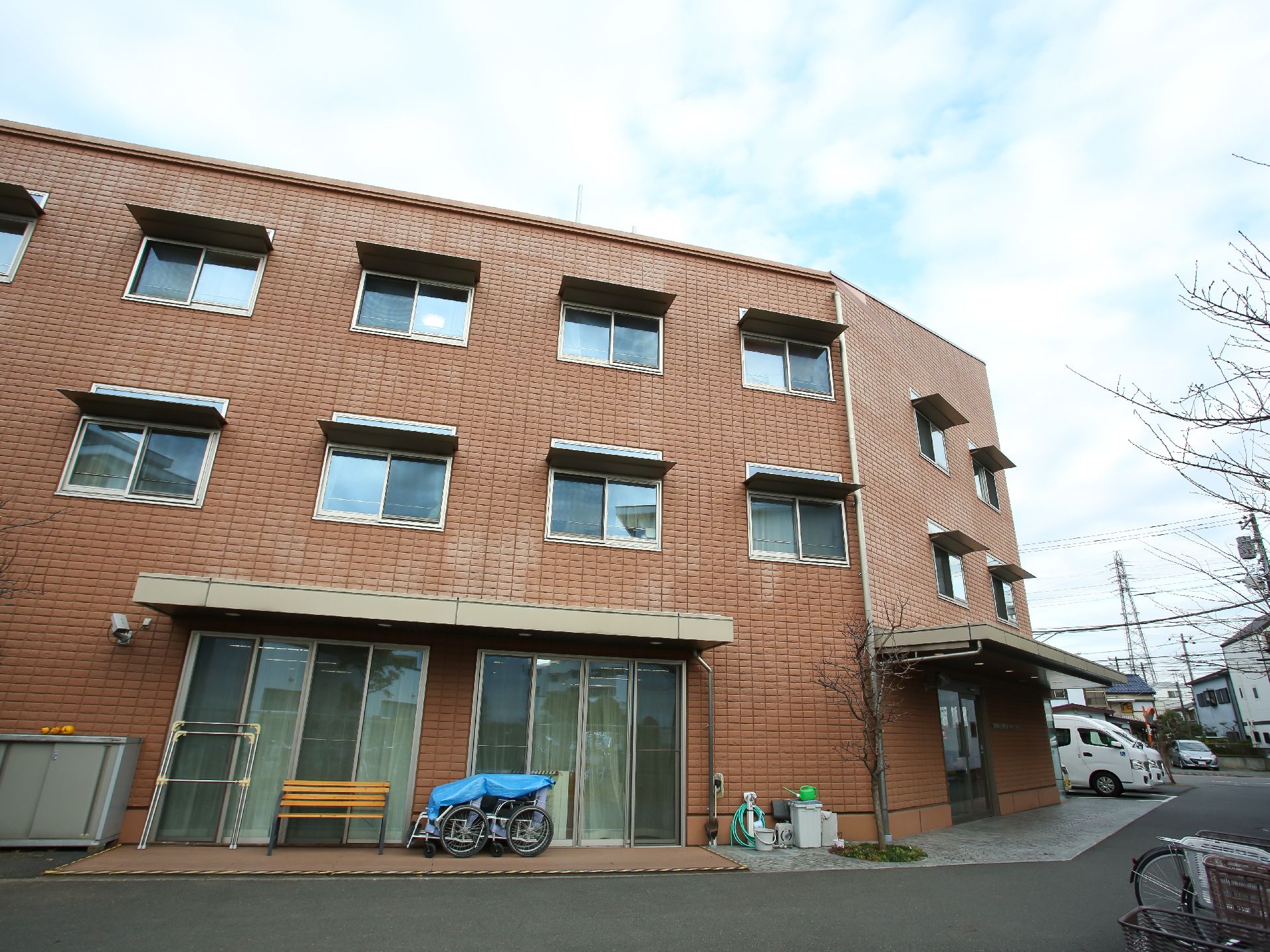 広い駐車場が隣接している茶色い屋根の介護施設