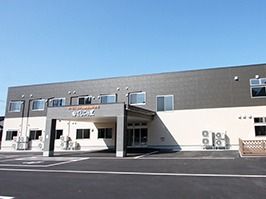 ツートンカラーのモダンなデザインの建物の写真。入り口付近に雨除けのひさしが付いている