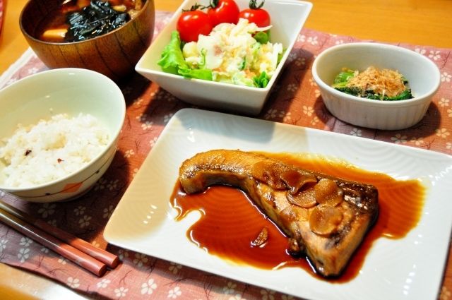 魚の煮つけとミニトマトやポテトサラダ、ほうれん草のおひたし、ご飯と味噌汁が付いたメニュー