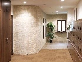 ブラウン系でまとめられた玄関には大きな下駄箱と観葉植物が置かれている。